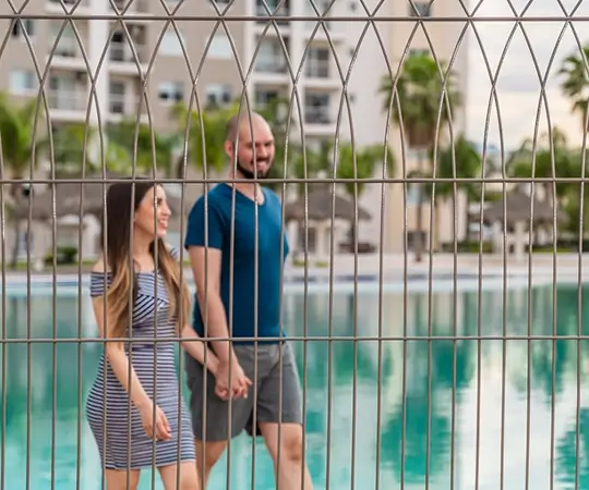 Reja Contemporanea Deacero Frente a una parjea caminando frennte a una piscina resort vacacional