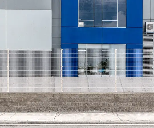 Reja Deacero Contemporánea frente a la fachada de un edificio industrial moderno en tonos azul y gris