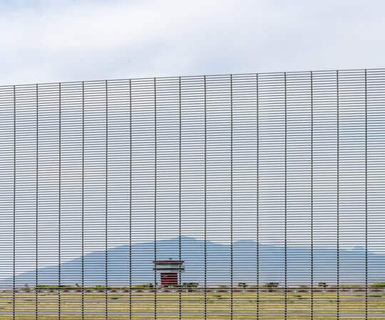 Reja Deacero Forte frente cubriendo una zona de alta seguridad con una torre a la lejanía